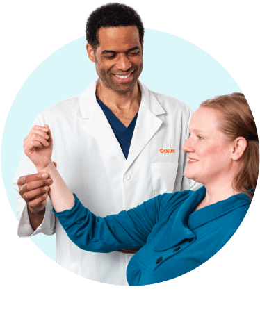 Optum WA orthopedic specialist in a white coat assisting a patient with arm movement