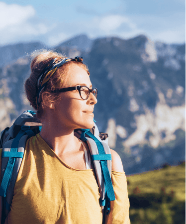 Confident woman with a backpack enjoying a scenic mountain view