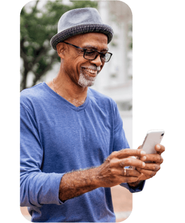 Smiling senior man using his smartphone outdoors, exploring Medicare options