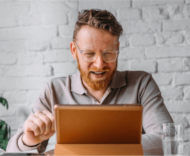 Man with glasses using a tablet for a virtual healthcare visit