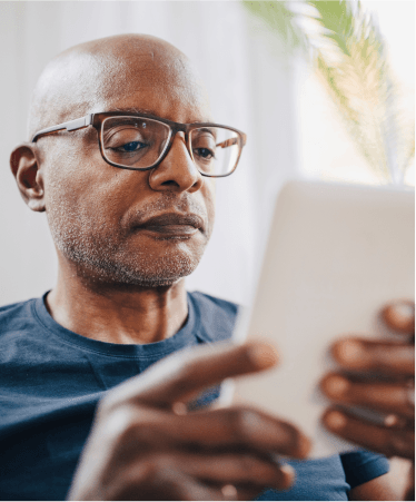 Man with glasses using tablet for convenient virtual healthcare visit