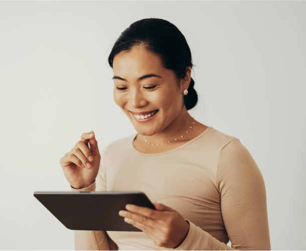 A smiling woman using a tablet