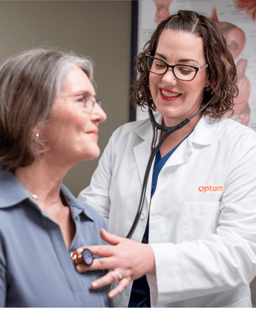 Optum WA healthcare professional using a stethoscope to examine a patient, representing expert and compassionate gastroenterology care