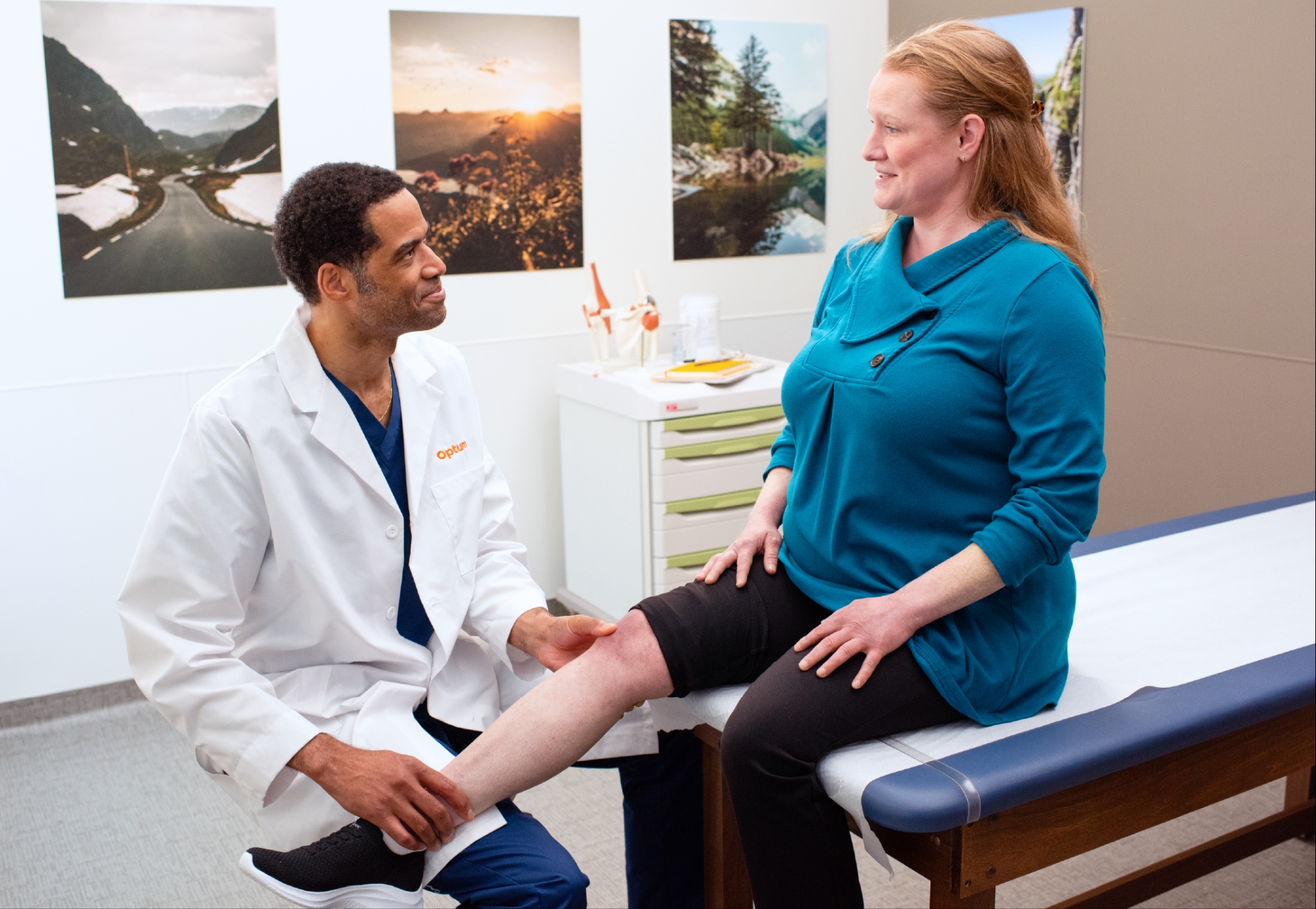 Optum WA doctor in a white coat examining a patient's knee in a medical office