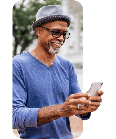 Smiling senior man using his smartphone outdoors, exploring Medicare options